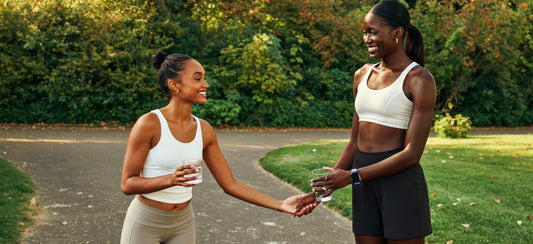 Two young adults cooling down together after a park workout