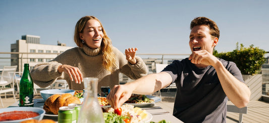 Two young adult friends sharing an outdoor weekend brunch.