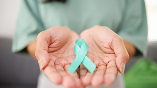 Hands holding a teal awareness ribbon symbolizing brain tumor support and hope