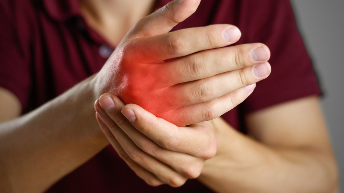 person holding wrist with red highlight indicating arthritis pain types of arthritis