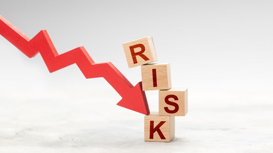 Red downward arrow pointing at wooden blocks spelling the word RISK, symbolizing bird flu no risk to poultry consumers