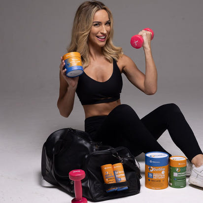 woman holding 6-Week Total Transformation GutSlim supplements with fitness gear and pink dumbbells