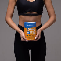 Person in black workout clothes holding GutSlim Probiotics Diet Shake vanilla protein powder container