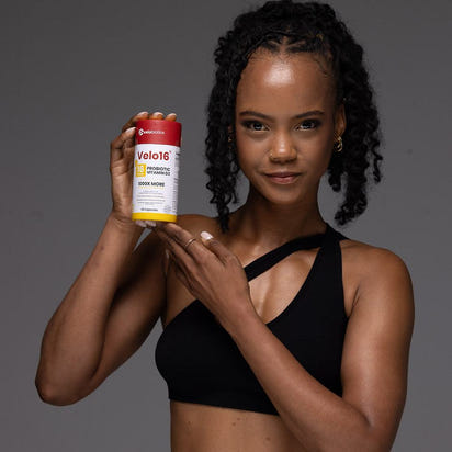 Woman holding Velo16 Probiotics Vitamin D3 supplement bottle promoting immune and bone health