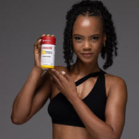 Woman holding Velo16 Probiotics Vitamin D3 supplement bottle promoting immune and bone health